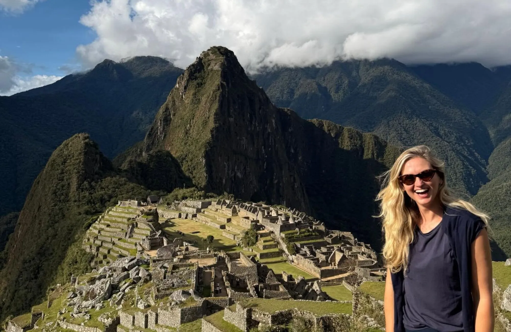 Jen smiling in front of a dramatic mountain landscape